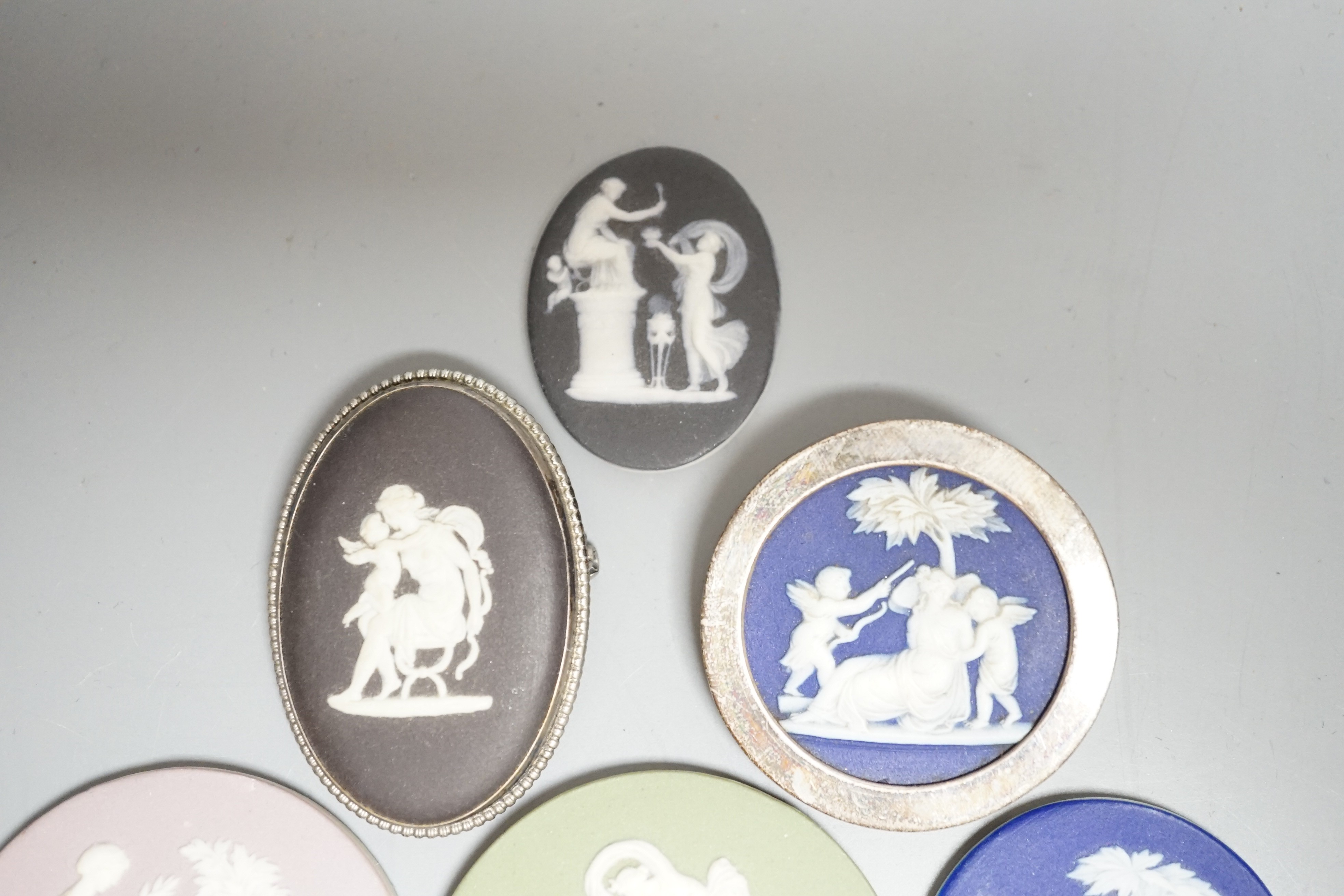 Two Wedgwood jasperware brooches, 20th century and four 19th century Wedgwood jasper plaques, largest 5.2 cm diameter